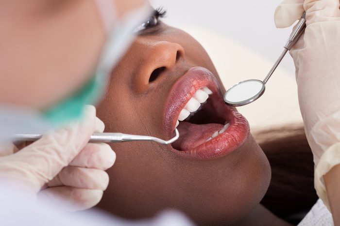 female patient having her teeth examined by dentist