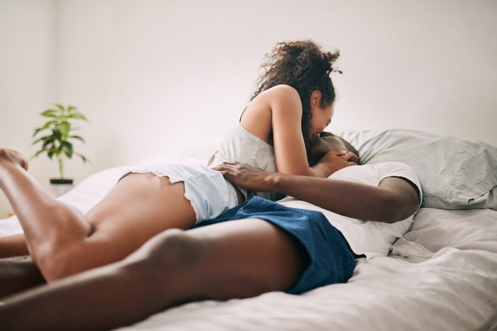 couple kissing in bed