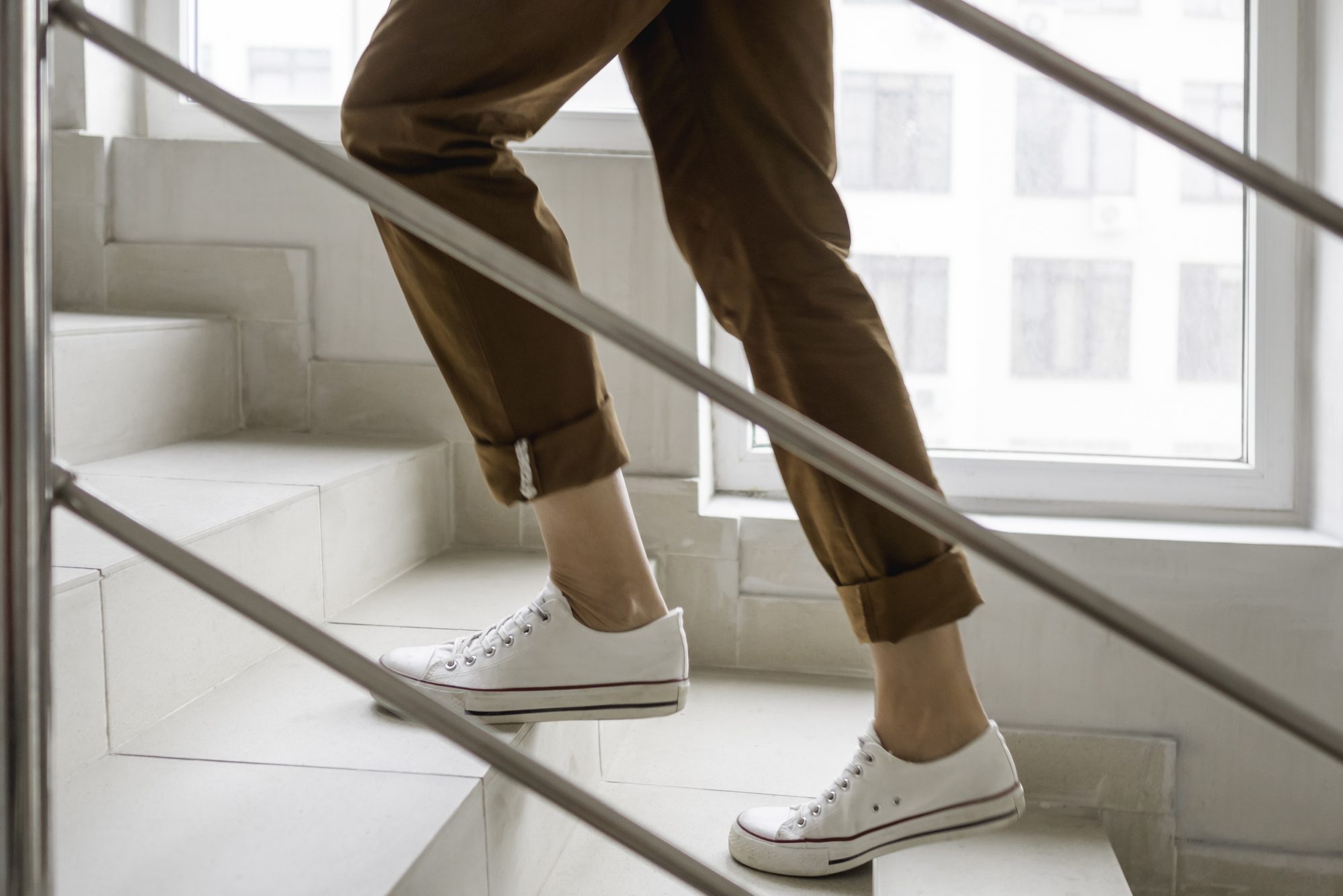 lower half of woman walking up stairs