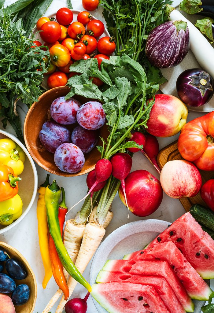 Fresh homegrown vegetables and fruits on kitchen table, summer harvest still life, table top view