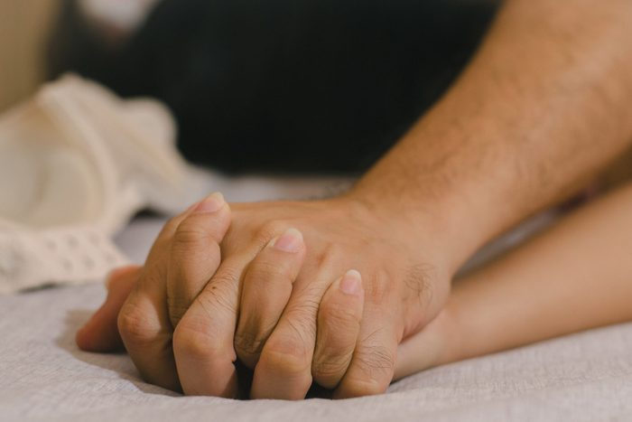 Hands of couple lovers having sex on a bed in morning with lust and love, Close up hands of a couple having sex on a bed
